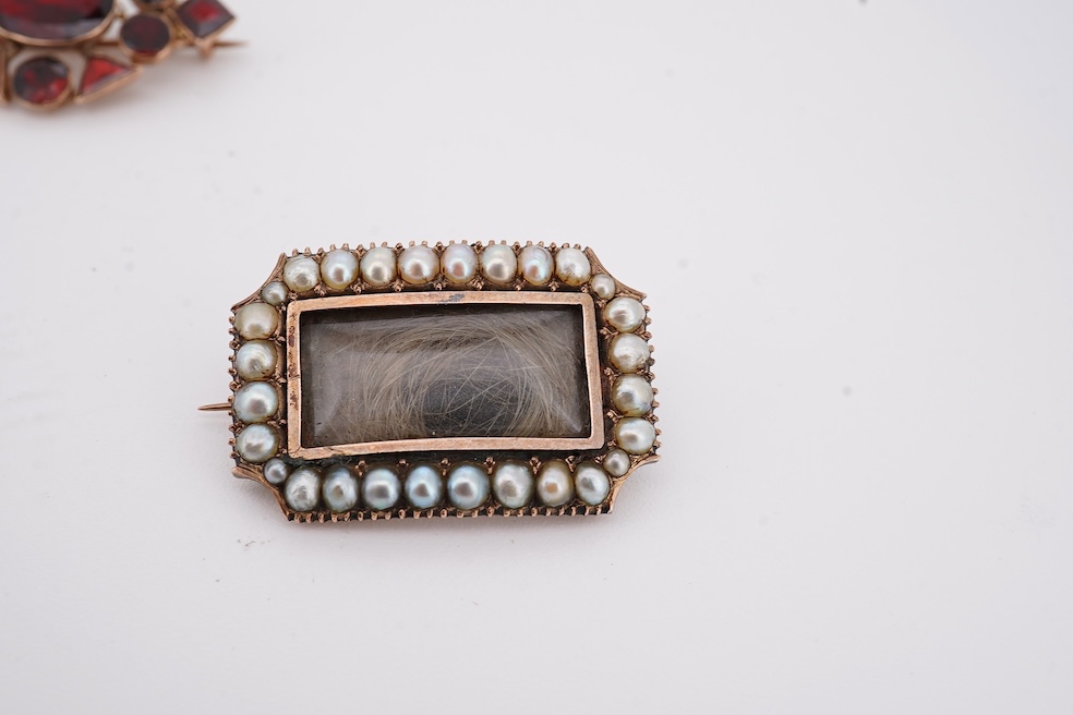 Three assorted Victorian brooches including a 9ct and garnet cluster by Murrle Bennett & Co, 27mm, a micro mosaic bar brooch and a yellow metal and split pearl mourning brooch, together with a gem set oval pendant. Condi